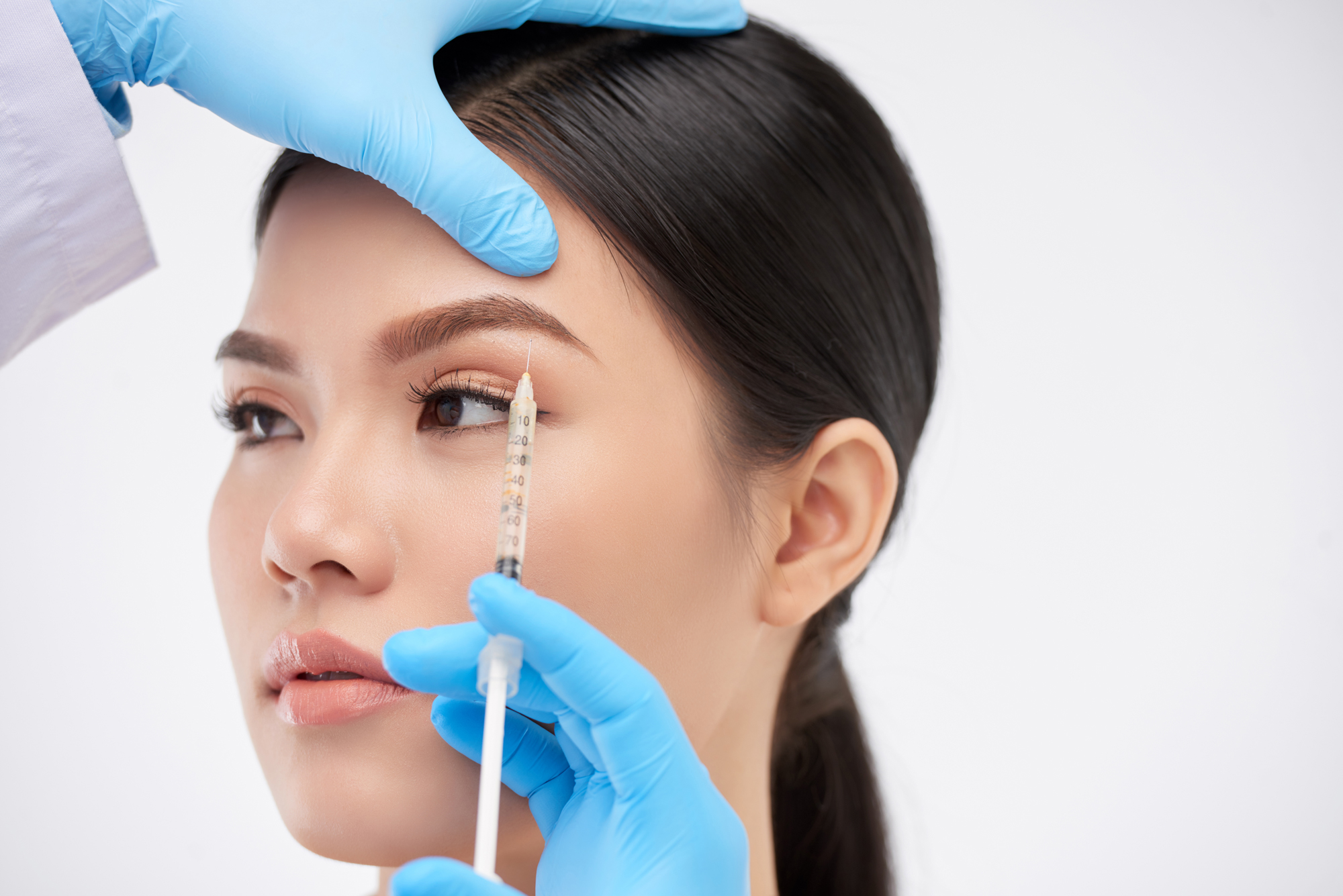 Close-up of botox brow lift injection placed precisely above the eyebrow for subtle lift.