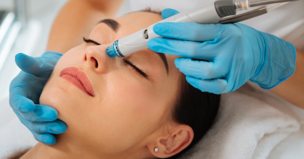 Close-up of a female undergoing a HydraFacial procedure with a provider